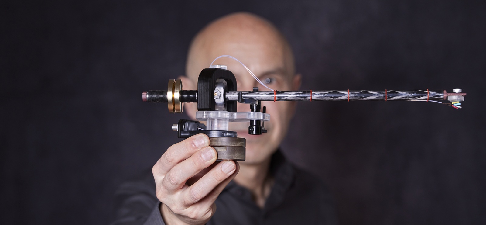 Side view of the flex tonearm (left). Matthias Kurz is holding the arm with his right hand outstretched